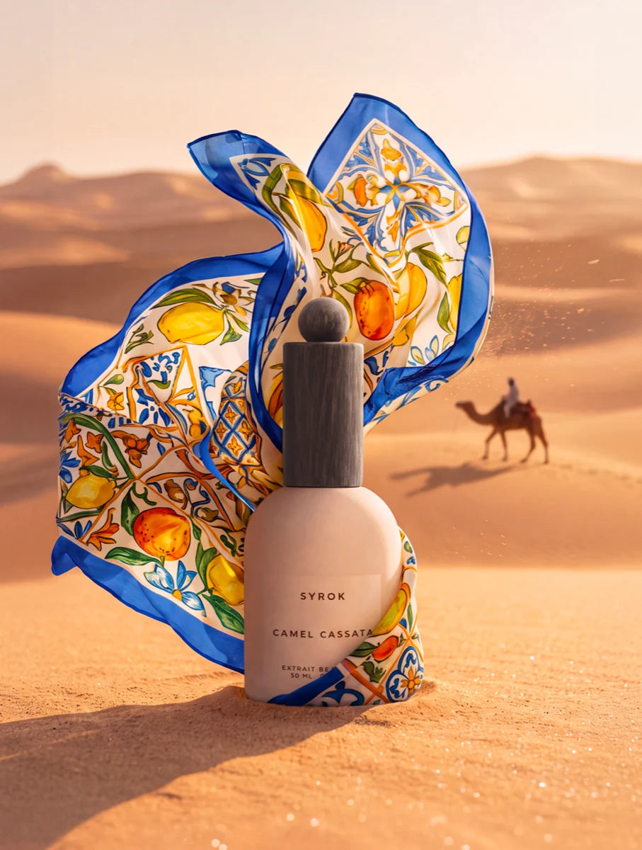 Syrok Camel Cassata bottle among the dunes, with a Sicilian maiolica-patterned scarf